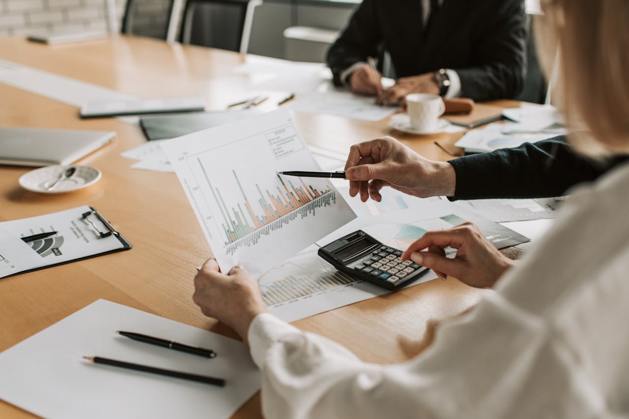 why-choose-us Professionals reviewing financial graphs and charts during a meeting.